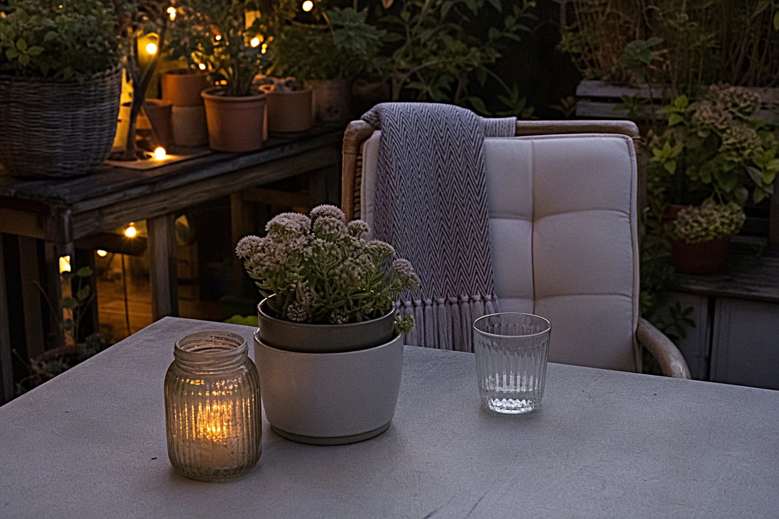 Stimmungsvoll mit warmweißen LED-Lichterketten beleuchtete Gartenterrasse am Sommerabend